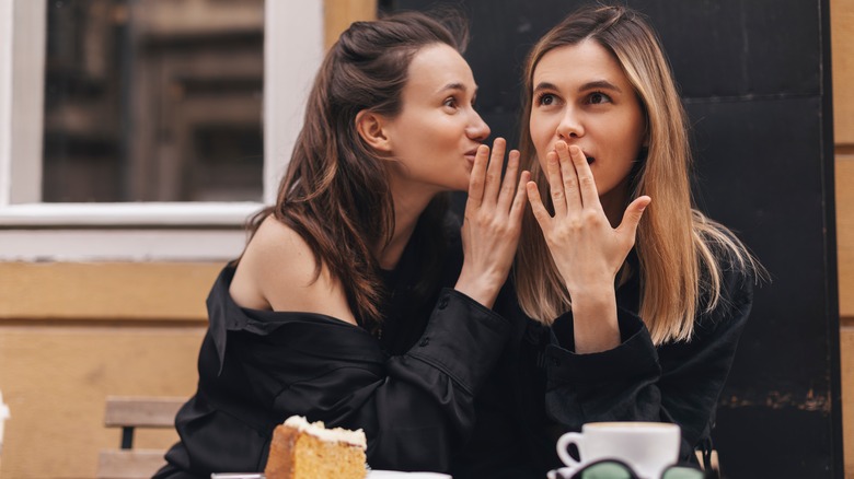 Woman whispering to other woman