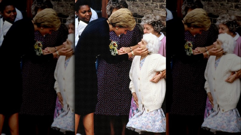 Princess Diana speaking to an elderly woman