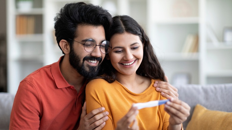 Smiling couple looking at pregnancy test