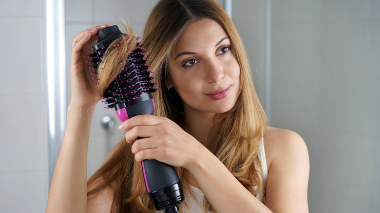 woman using brush hairdryer