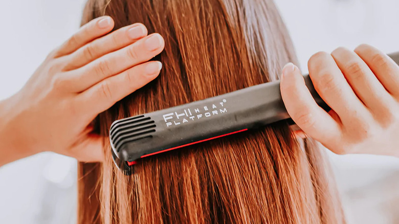 back of person's head straightening long hair