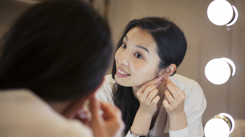 woman putting in earrings