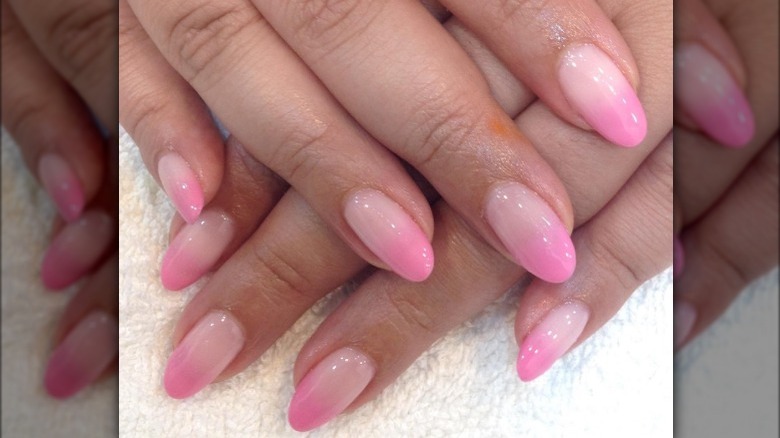 Woman posing with dark pink to light pink ombré nails