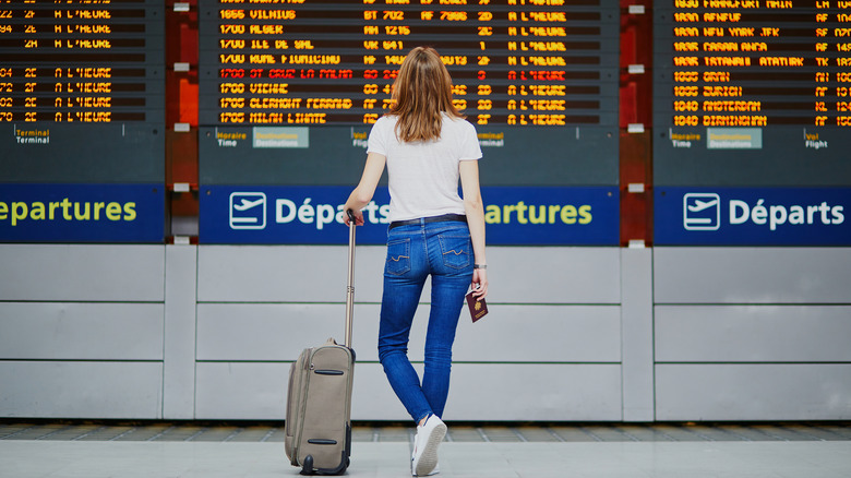 Woman looking at flight board in airport