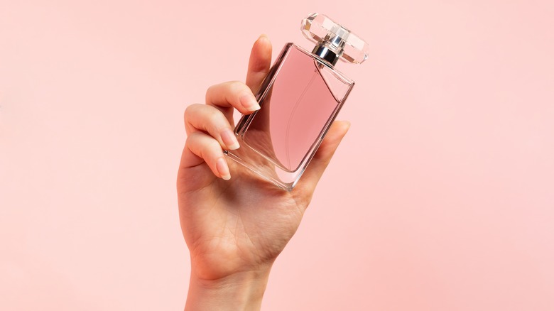 Woman's hand holding a perfume bottle 