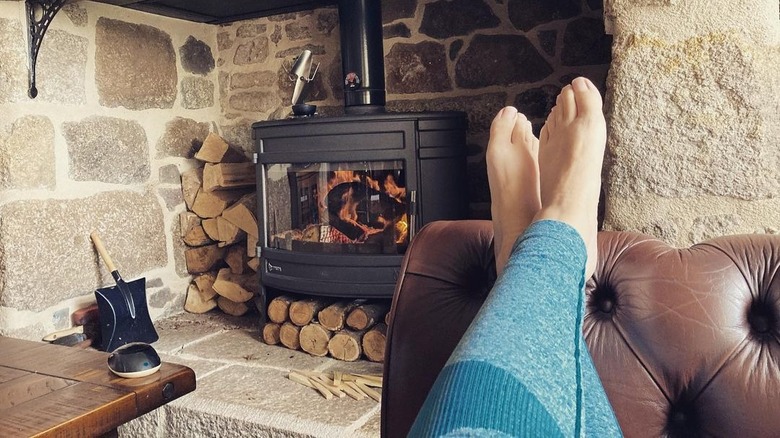 Woman relaxing near her fireplace at home