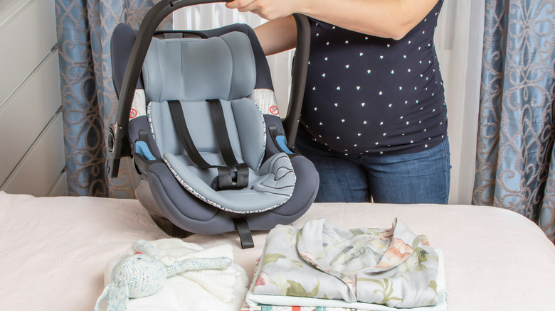 Pregnant woman with carseat