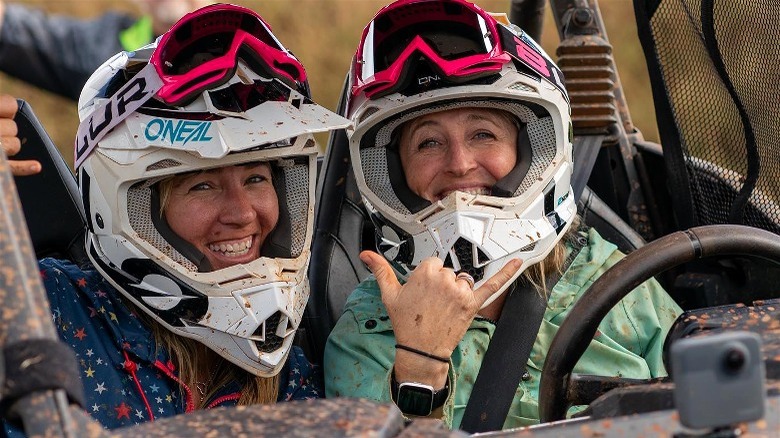Two happy women in muddy helmets