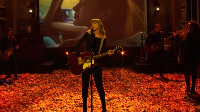 Taylor Swift holds guitar on stage