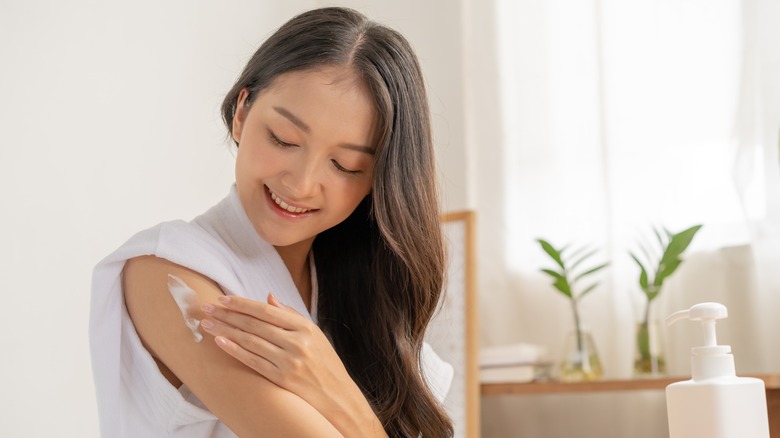 Woman smiling applying cream