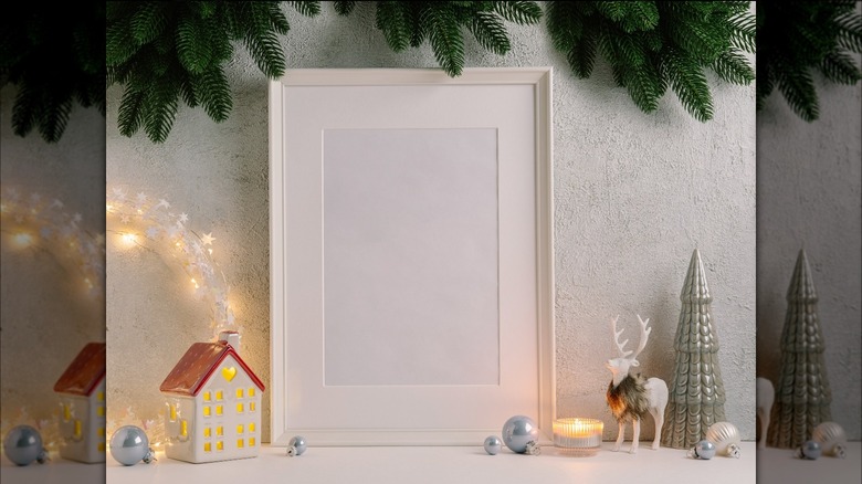 White frame next to Christmas decor on mantel