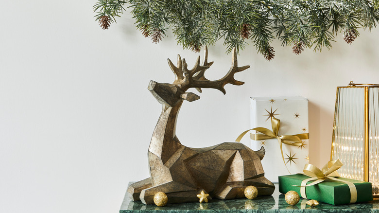 Gold reindeer figurine next to other Christmas decor