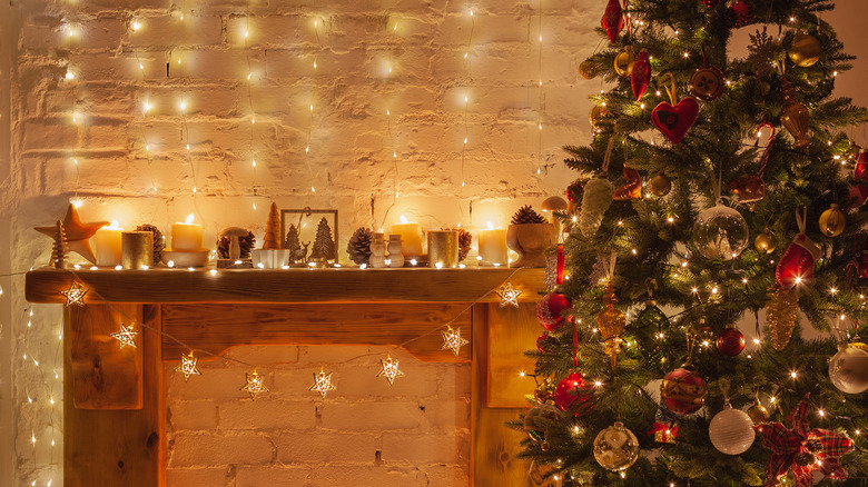 Faux mantle decorated with many string lights next to Christmas tree