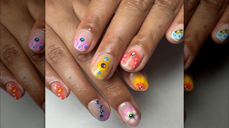 Hands featuring multi-colored flower nails