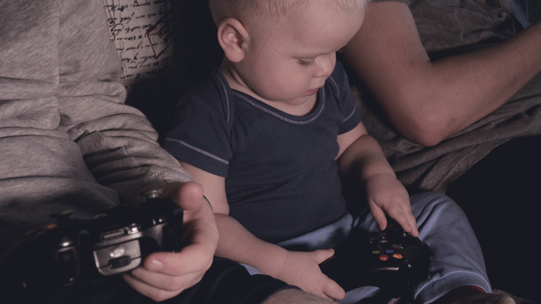 baby holding video game console controller