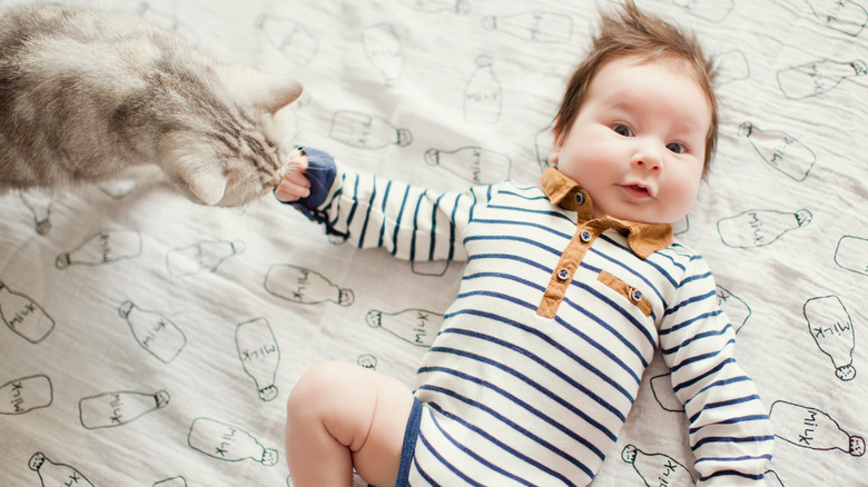 baby lying with cat