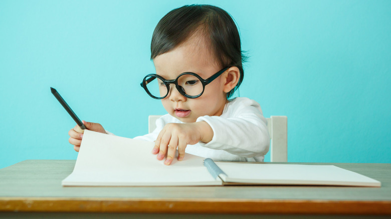 Baby with glasses and notebook