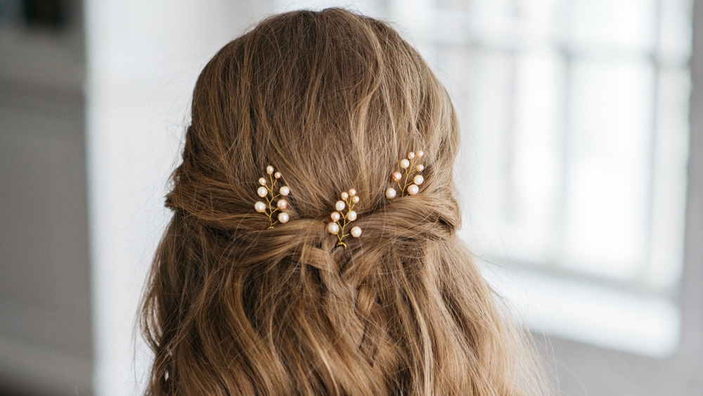 A women wearing pearls in hair, looking away