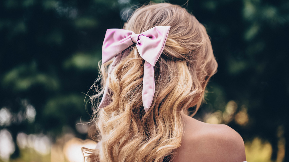 A woman wearing a ribbon in her hair, facing away