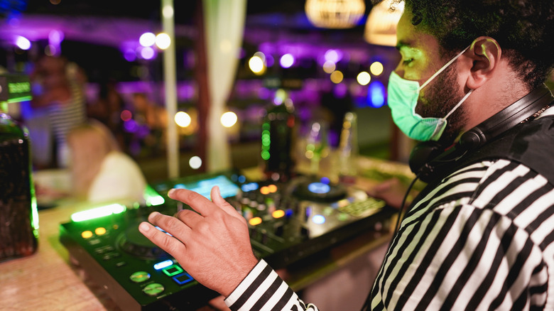 A masked performer plays music at a live event