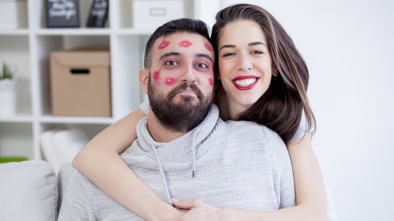 man covered in woman's kisses clingy relationship