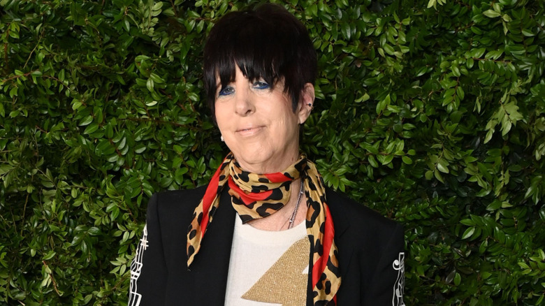 Diane Warren posing against a leafy background