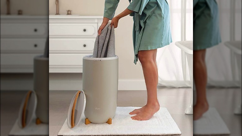 Person removing a towel from towel warmer