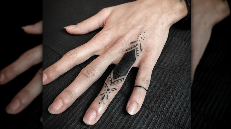 Hand with bold tattoos