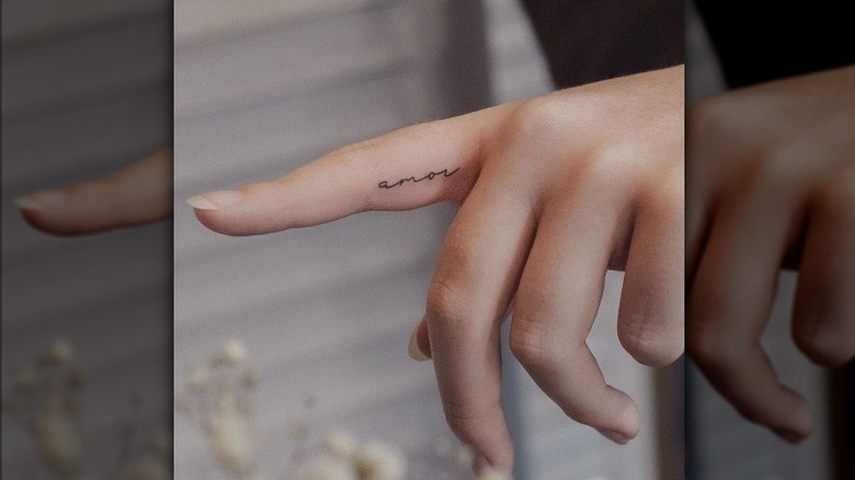 Finger with amor tatoo