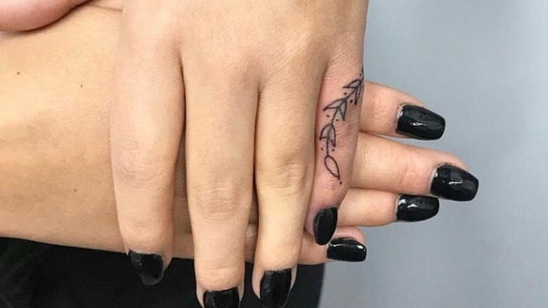 hands with pinky tattoo