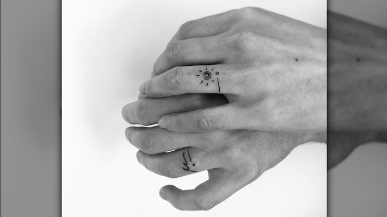 Hands with ring tattoos