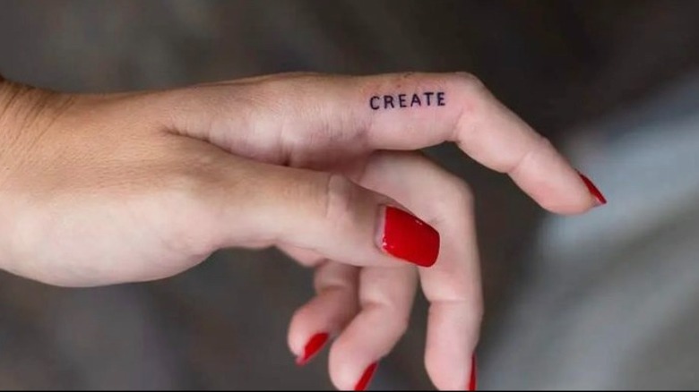 Hand with "create" tattoo