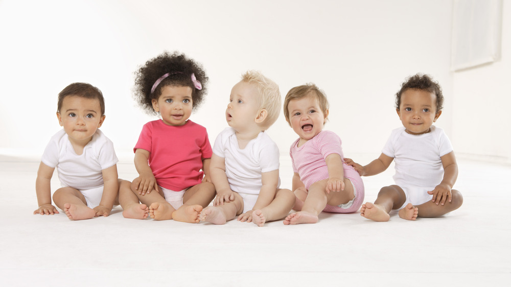 5 babies sitting on floor