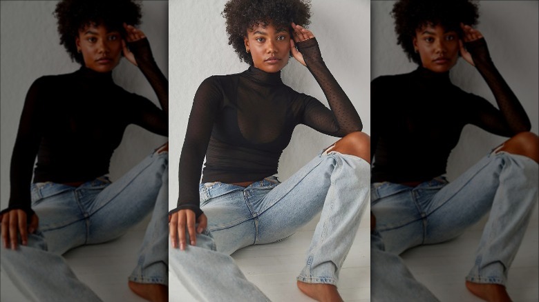 Free People model wears sheer turtleneck and jeans