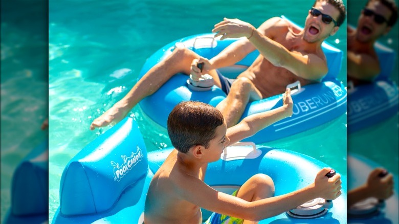 Man and child laughing on pool floats