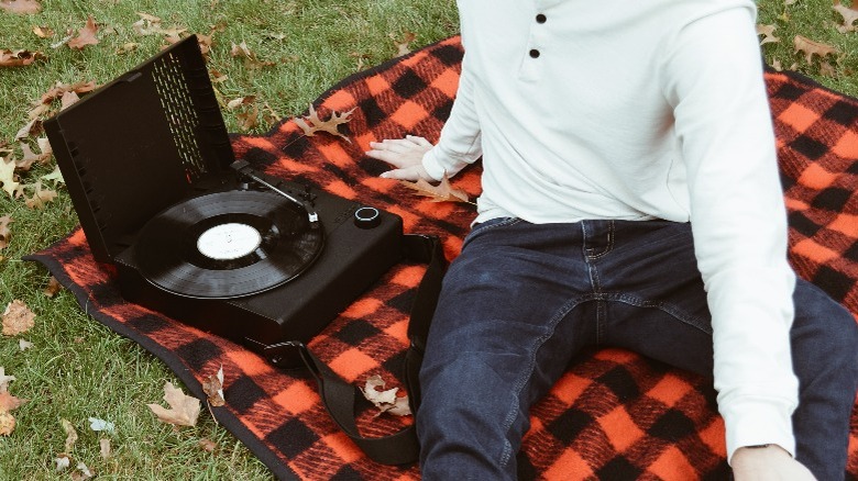 Person sitting with a portable record player 