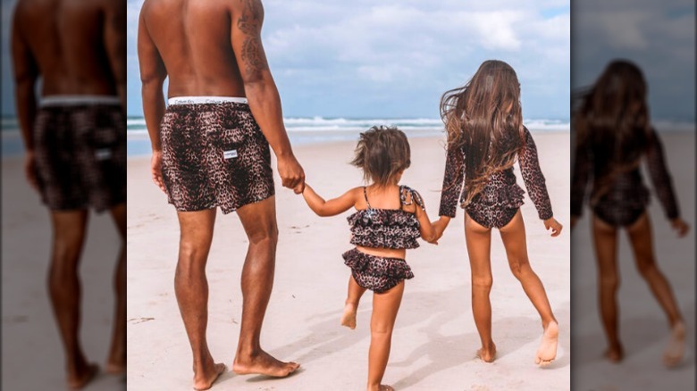 Man and children on beach in matching leopard swimsuits