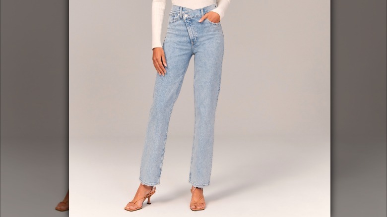 Model wearing crisscross asymmetrical jeans