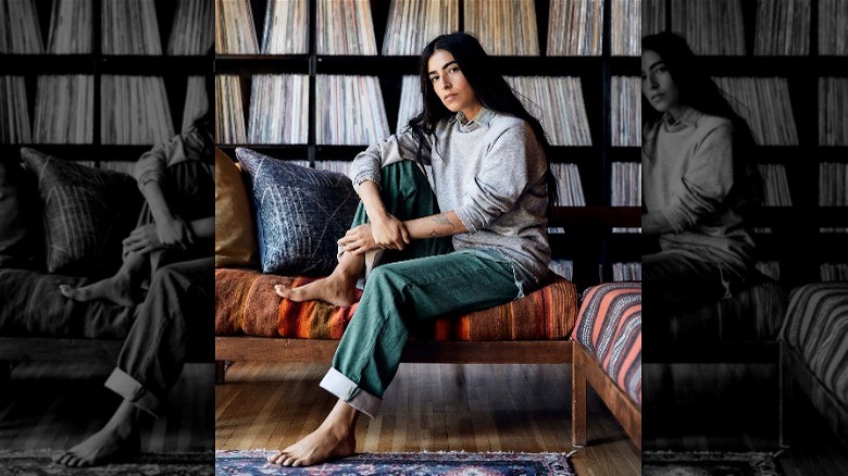 Woman in baggy jeans on an orange couch