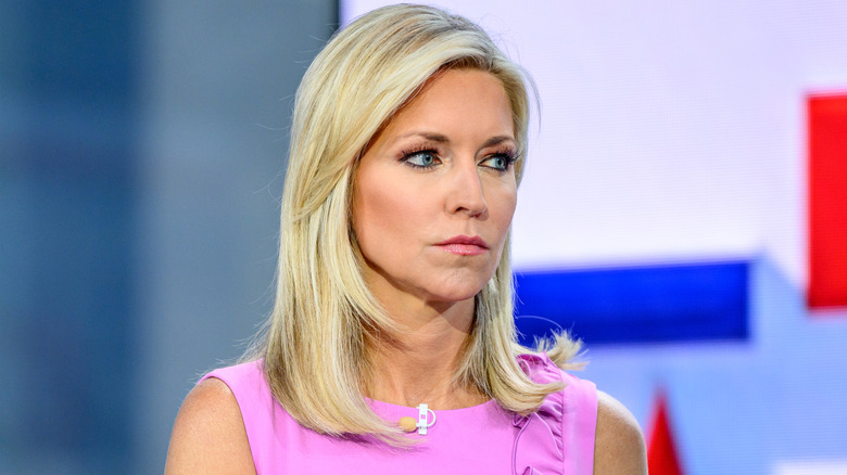 Ainsley Earhardt in a pink dres with a straight face during an interview with Robert F. Kennedy