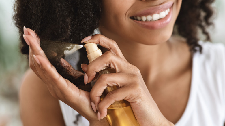 Woman spraying ends of hair