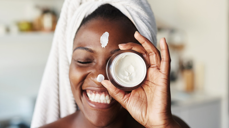 Woman moisturizing face