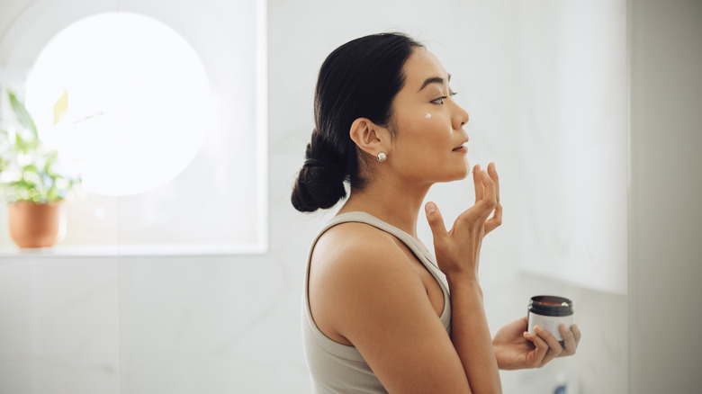 Woman putting on moisturizer