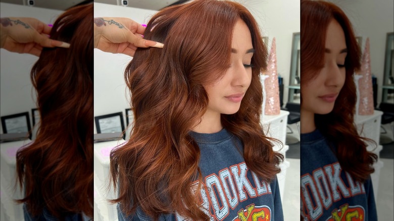 Angled side view of strawberry brown hair color on curtain bangs