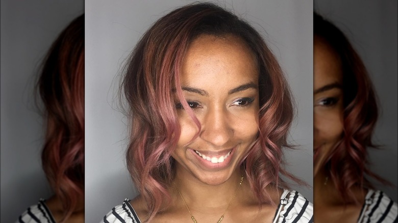 Smiling woman with rose-colored brunette curls