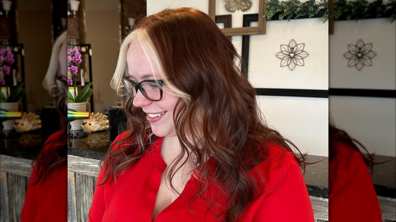 Angled side view of strawberry brown hair with blond money pieces