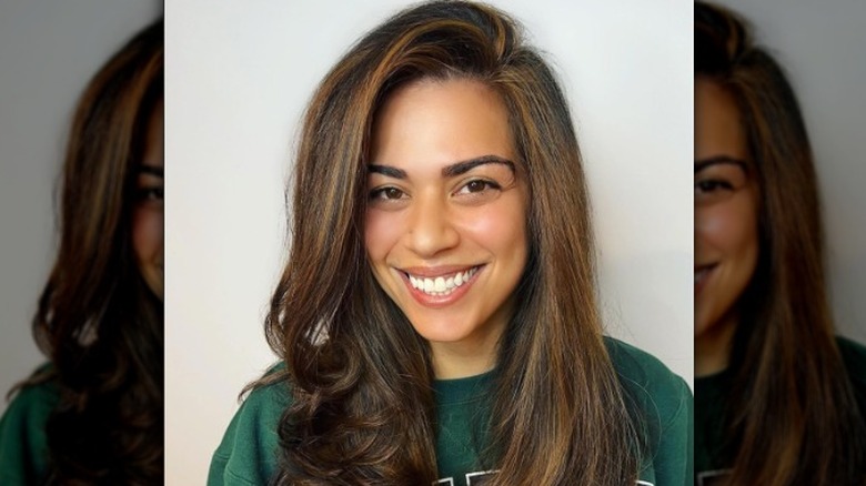 Person with long brown hair smiling