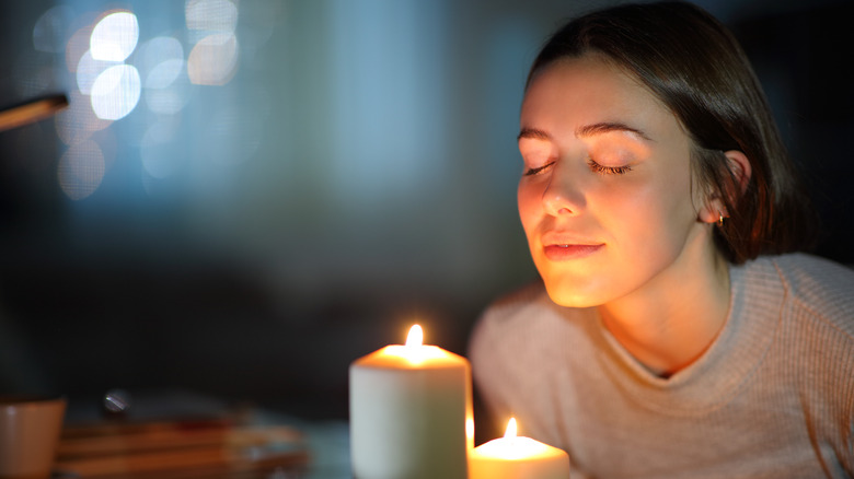 Woman smelling candles