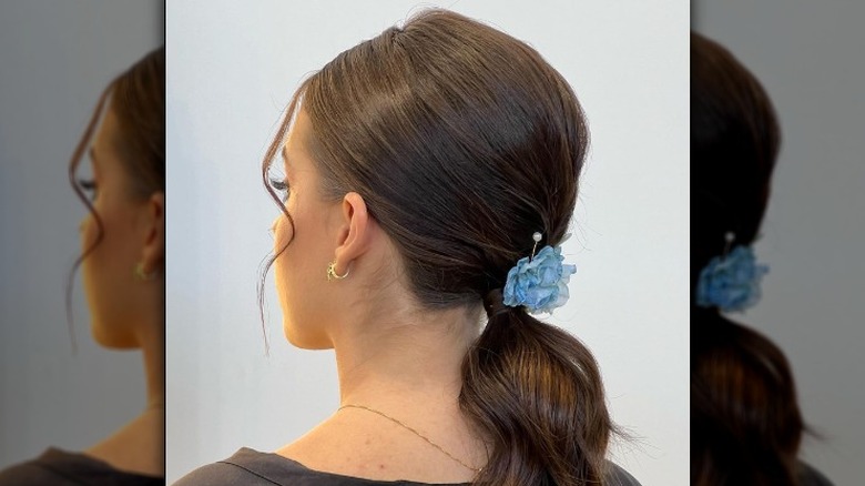 Low ponytail with blue flower accessory