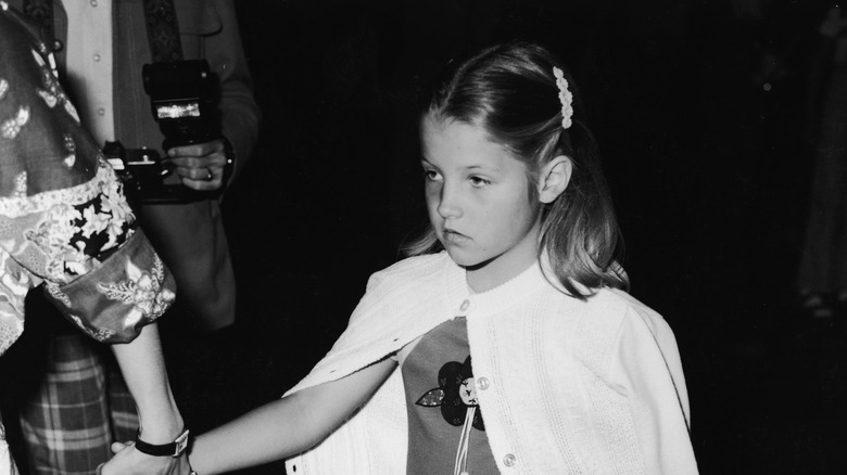 Lisa Marie Presley as a child holding hand